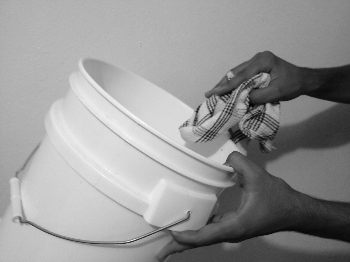 Image of someone cleaning the inside of a bucket water filter.